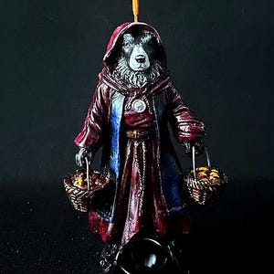 May include: A black and white dog wearing a red and blue robe holds two baskets of fruit. The dog is a incense burner with a black bowl for incense.