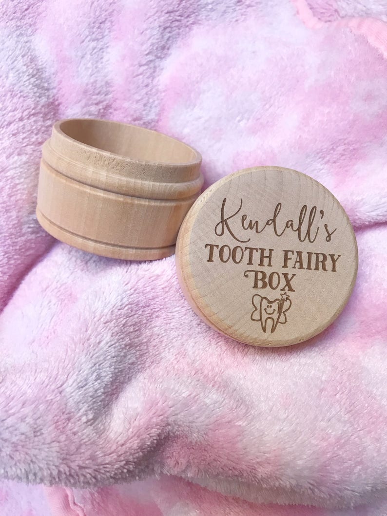 May include: A wooden tooth fairy box with the inscription "Kendall's Tooth Fairy Box" and a small tooth with fairy wings engraved on the lid.
