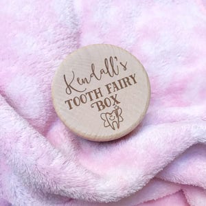 May include: A wooden tooth fairy box with the inscription "Kendall's Tooth Fairy Box" and a small illustration of a tooth with a fairy wand.