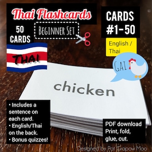 May include: A set of 50 Thai flashcards for beginners. The cards feature English words and their Thai translations. The front of the card shows the English word "chicken" and the back of the card shows the Thai word "ไก่" (pronounced "gai"). The cards are designed to help learners of the Thai language.