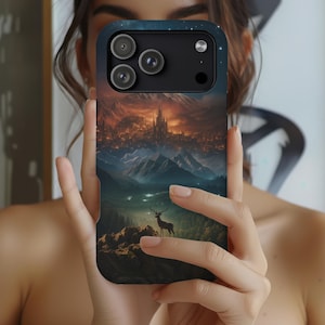 May include: A smartphone case featuring a fantasy landscape with a castle, mountains, and a deer. The case has a dark blue sky with stars at the top and a detailed illustration of a city and mountains.