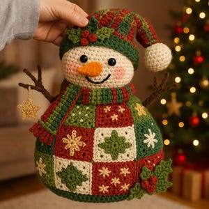 Può includere: Un pupazzo di neve all'uncinetto fatto a mano con un design festivo. Il pupazzo di neve ha una testa color crema, un naso a carota arancione e un corpo patchwork verde e rosso. Ha un cappello e una sciarpa abbinati e una stella d'oro.