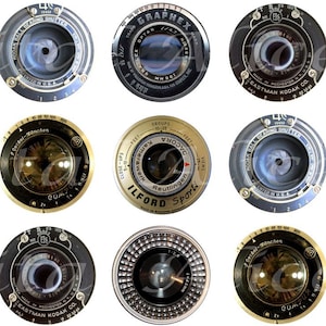 May include: Twelve vintage camera lenses in various colours and designs. The lenses are round and have a black, silver, or gold finish. Some of the lenses have text on them, including "GRAPHEX", "ILFORD", and "EASTMAN KODAK CO."