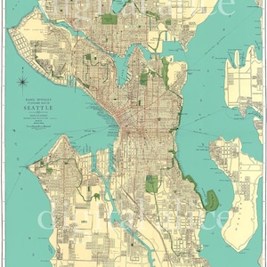 Op de afbeelding: Een vintage kaart van Seattle, Washington, gedrukt in bruine, rode en groene inkt op een crèmekleurige achtergrond. De kaart toont de straten, parken en waterwegen van de stad. De kaart is getiteld "Rand McNally Standard Map of Seattle".
