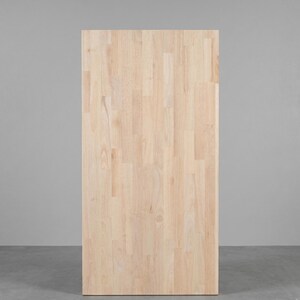 May include: A rectangular butcher block panel made of light-colored, unfinished wood. The surface features a finger-jointed construction with vertical grain patterns and natural variations in tone, showcasing a smooth, sanded texture throughout.