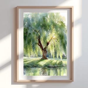 May include: Watercolor painting of a weeping willow tree in a wooden frame. The tree has a brown trunk and cascading green leaves, with sunlight filtering through. The scene includes a grassy area and a body of water, creating a serene landscape.