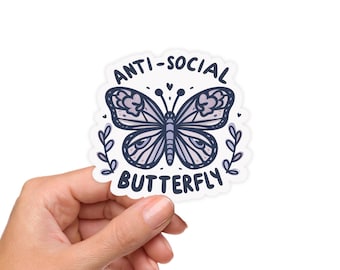 May include: A sticker with a butterfly design in shades of purple and blue, with the words "ANTI-SOCIAL BUTTERFLY" in a handwritten style. The butterfly is surrounded by small hearts and leaves.