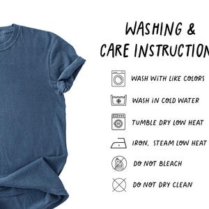 Op de afbeelding: Een blauw T-shirt met opgerolde mouwen. De afbeelding bevat was- en onderhoudsinstructies: wassen met dezelfde kleuren, wassen in koud water, in de droger op lage temperatuur, strijken op lage temperatuur, niet bleken en niet chemisch reinigen.