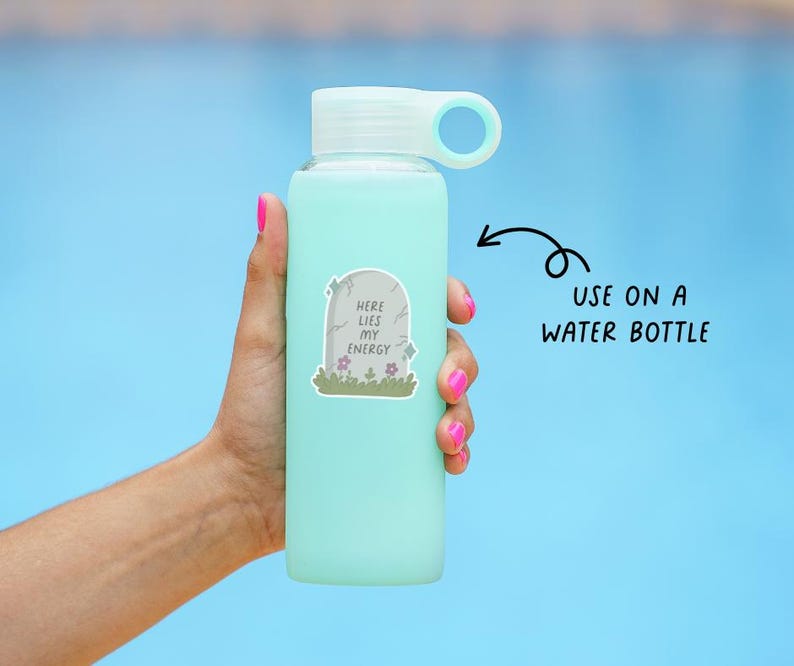 May include: A light blue water bottle with a white lid and handle is held against a blue background. A sticker on the bottle reads "Here Lies My Energy" with a tombstone design. The text "USE ON A WATER BOTTLE" is also visible.