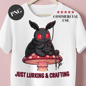 May include: White t-shirt featuring a cartoon moth with red eyes knitting a sweater while sitting on a red and white mushroom. The text "JUST LURKING & CRAFTING" is below the image. The shirt also has a "PNG" logo.