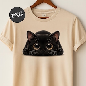 May include: A beige t-shirt featuring a black cat illustration with large, expressive eyes. The cat is lying down, with its paws visible. The shirt has short sleeves and a round neckline. A PNG logo is in the upper left corner.