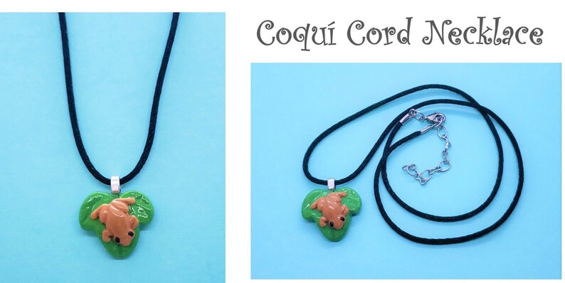 May include: A black cord necklace with a green leaf charm featuring a brown frog. The necklace is called "Coqu&iacute; Cord Necklace".