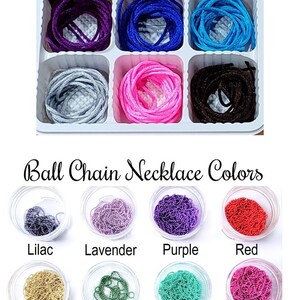 May include: A white tray with six compartments, each containing a different color of nylon cord. The colors are purple, royal blue, light blue, silver, pink, and black. Below the tray, there are 12 small glass containers, each filled with a different color of ball chain. The colors are lilac, lavender, purple, red, gold, green, aqua, hot pink, silver, teal, turquoise, and cobalt.