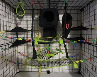 May include: A black wire cage with a variety of green and black hanging accessories for small pets. The cage has a black fabric hammock, a black fabric tunnel, and a green fabric hanging toy.