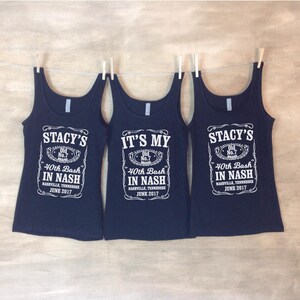 Puede incluir: Tres camisetas de tirantes negras con texto blanco. El texto en la camiseta del medio dice "It's My 40th Bash In Nash Nashville, Tennessee June 2017". El texto en las camisetas de la izquierda y la derecha dice "Stacy's 40th Bash In Nash Nashville, Tennessee June 2017".