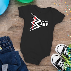 May include: Black baby onesie with a white lightning bolt graphic and the text "I'm the baby" in white.