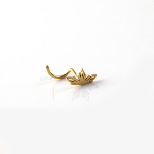 Puede incluir: Anillo de nariz de oro con un diseño de sol.