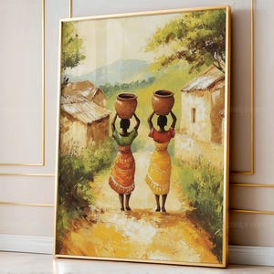 May include: A framed painting depicts two women carrying clay pots on their heads, walking along a dirt path. The artwork features a warm color palette with yellows, oranges, and greens, suggesting a rural scene. Buildings and trees are visible in the background.