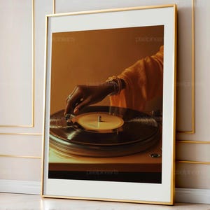 May include: A framed print featuring a close-up of a turntable with a vinyl record. A hand, adorned with jewelry, is adjusting the needle. The image has a warm, sepia-toned color palette, suggesting a vintage or retro theme.