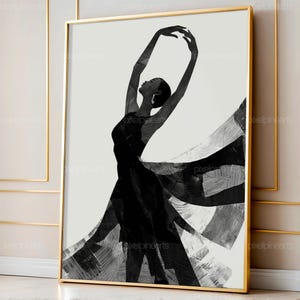 May include: Black and white art print of a ballerina in a flowing dress, arms gracefully arched overhead. The artwork is framed in a gold-colored frame, adding a touch of elegance. The dancer's silhouette is contrasted against a white background.