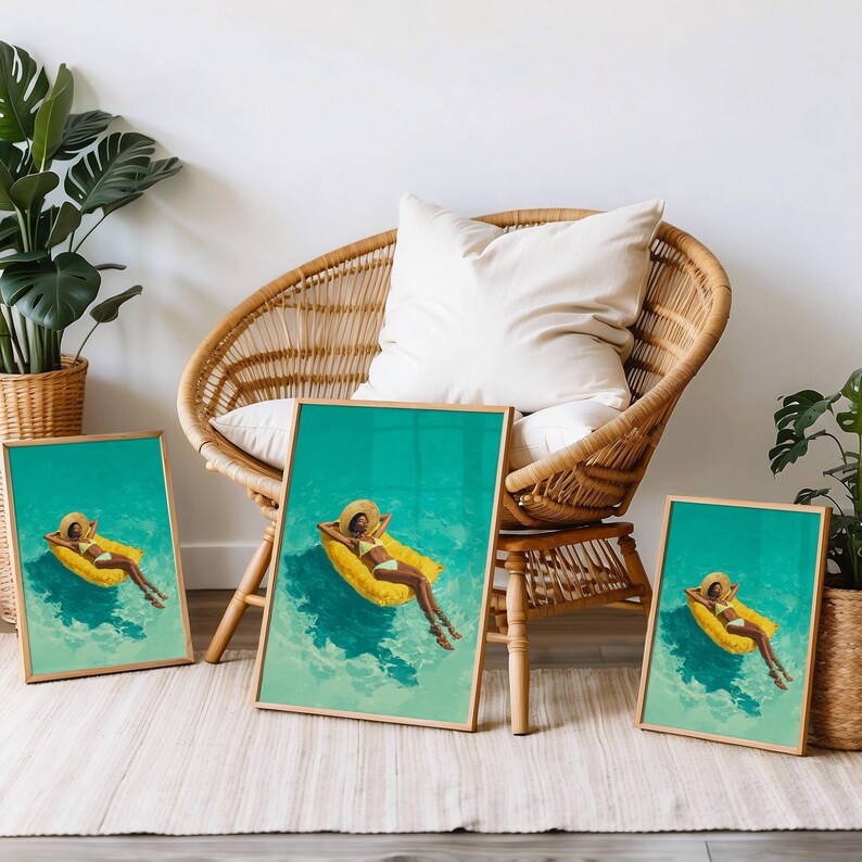 May include: Three framed art prints featuring a person relaxing on a yellow pool float in turquoise water. The person wears a straw hat and a white bikini. The prints have gold frames and are displayed near a wicker chair.