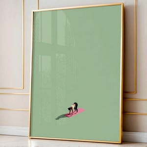 Puede incluir: Impresión artística enmarcada que representa a una persona en una postura de yoga sobre una esterilla rosa. La obra de arte tiene un estilo minimalista con un fondo verde claro y un marco dorado. La persona lleva pantalones negros y una camiseta blanca.