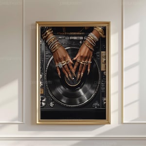 Peut inclure: Impression encadr&eacute;e d'une platine de DJ. Les mains, orn&eacute;es de bracelets et de bagues dor&eacute;es, ainsi que de longs ongles d&eacute;cor&eacute;s, se posent sur le disque vinyle noir. La platine est noire et argent&eacute;e, et le cadre est dor&eacute;.