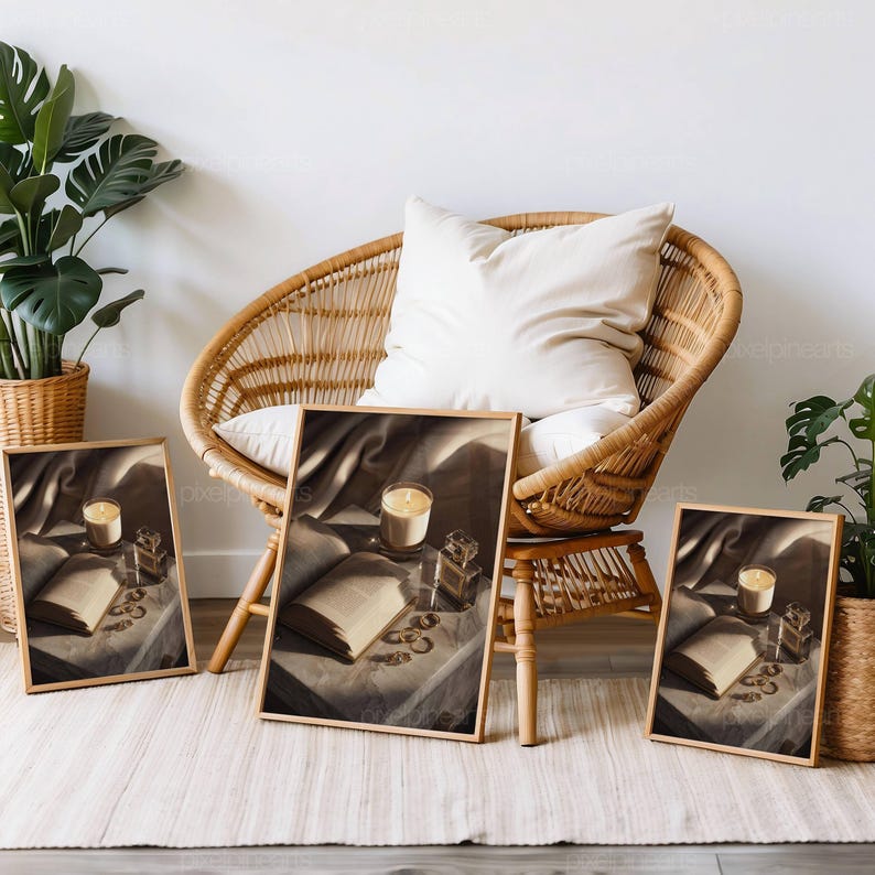 Puede incluir: Tres impresiones art&iacute;sticas enmarcadas que presentan una naturaleza muerta con una vela encendida, un libro abierto, frascos de perfume y joyas. Las impresiones son en tonos sepia, con un marco de madera. Una silla de mimbre y plantas est&aacute;n en el fondo.