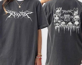 May include: Dark gray t-shirt with white graphic text "Stray Kids" on the front. The back features a graphic of cartoon animal faces and the text "domin Stray Kids". The shirt has a crew neck and short sleeves.