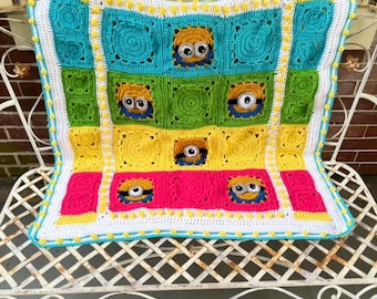 This is a handcrafted Minion-themed baby blanket, featuring a vibrant patchwork of colorful crochet "granny squares" with character-inspired