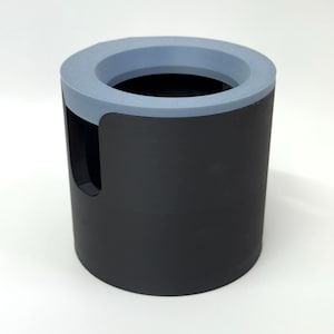 Puede incluir: Un recipiente cil&iacute;ndrico negro con un borde azul claro. El recipiente tiene un recorte en un lado. El interior es negro. Podr&iacute;a ser un organizador de escritorio o un art&iacute;culo similar.