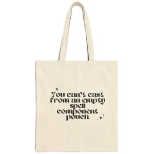 Könnte beinhalten: Eine beige Tragetasche mit schwarzem Text, der "You can't cast from an empty spell component pouch." lautet.