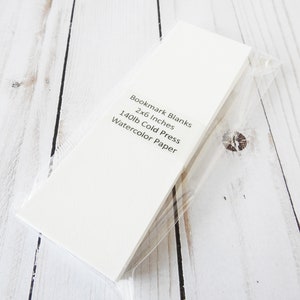 May include: A pack of white bookmark blanks made of 140lb cold press watercolor paper. The pack is 2x6 inches.