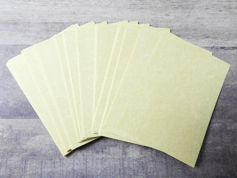 May include: A stack of 12 blank, off-white, textured paper sheets.