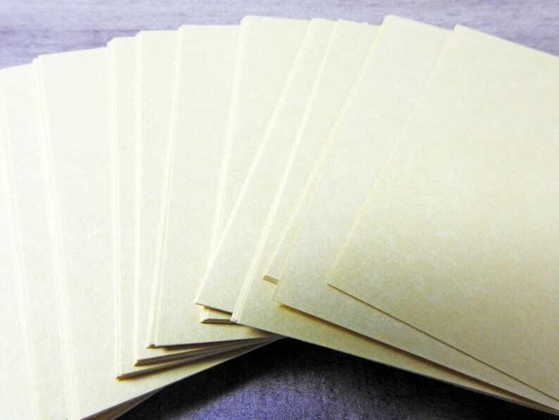 May include: A stack of blank, off-white index cards, fanned out in a semi-circle.