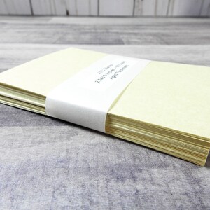 May include: A stack of 250 blank ivory note cards with a white label that reads "FTC Stamps 250 5x7 Note Cards 100lb Paper".