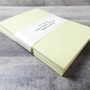 May include: A stack of 50 blank ATC cards in a pale yellow color. The cards are 2.5x3.5 inches and are made of aged parchment paper.