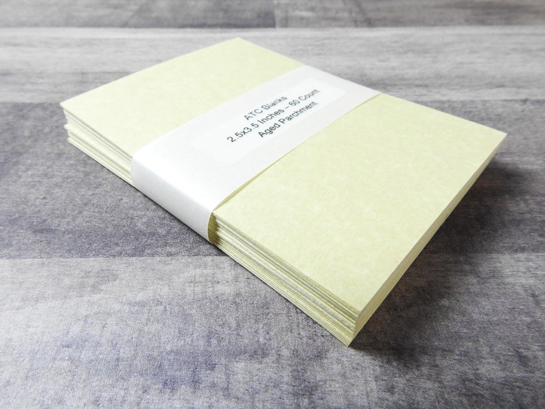 May include: A stack of 50 blank ATC cards in a pale yellow color. The cards are 2.5x3.5 inches and are made of aged parchment paper.