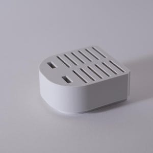 May include: A white plastic knife holder with slots for storing knives. The holder has a rounded rectangular shape and a smooth surface.