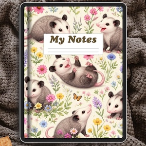Peut inclure: Un carnet rectangulaire avec une couverture couleur crème ornée d'un motif répétitif d'opossums gris et blancs, de fleurs sauvages colorées et d'un petit papillon. Une étiquette rectangulaire blanche centrale affiche le texte My Notes en brun.