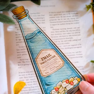 Puede incluir: Una taza de cerámica blanca con un asa negra y el texto "But First, Coffee" en negrita negra. La taza está sobre un fondo borroso. La taza mide aproximadamente 10 cm de altura.