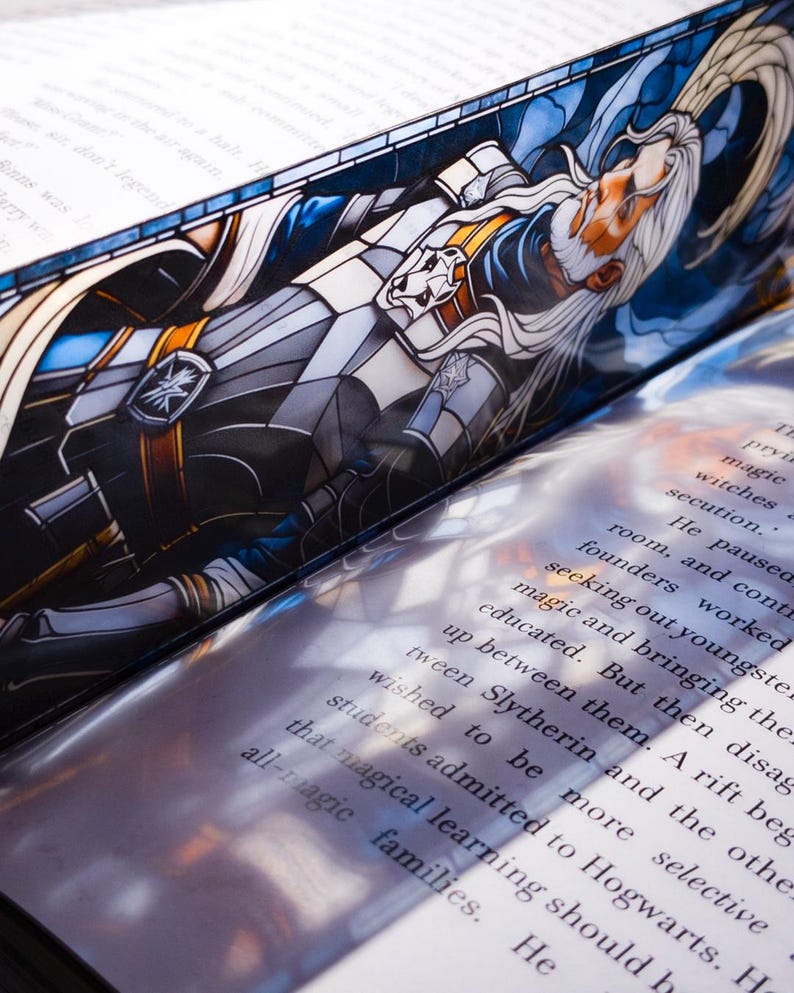 May include: A bookmark with a stained-glass design depicting a wizard with long white hair and a beard. The bookmark is placed within the pages of a book, with printed text visible.