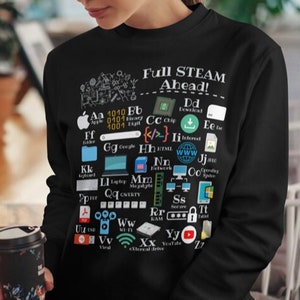 Puede incluir: Sudadera negra con un gráfico blanco de términos e iconos relacionados con la informática, incluyendo el texto "Full STEAM Ahead!"