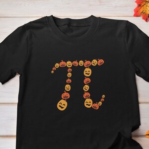 May include: Black t-shirt with a graphic of the mathematical symbol pi made up of orange and brown jack-o'-lantern faces.