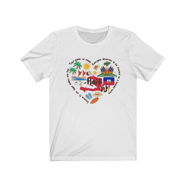 May include: White t-shirt with a circular design featuring a map of Haiti, palm trees, a sun, a coconut, a surfboard, flip-flops, and the Haitian flag. The text around the design reads "Tout moun se moun. Everyone deserves to be treated as a human being. Lespue f&egrave; viv. Hape makes one live."