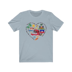 May include: Light blue t-shirt with a graphic design of the island of Haiti. The design includes the Haitian flag, palm trees, a boat, a coconut, and the text "Tout moun se moun, Lespwe f&egrave; viv. Hope makes us live, Everyone deserves to be treated as a human being."