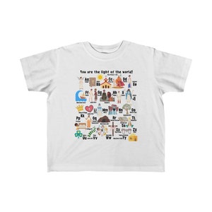 May include: White youth t-shirt with a colorful alphabet design featuring illustrations of Christian themes. The shirt has the text "You are the light of the world!" and "Matthew 5:14".