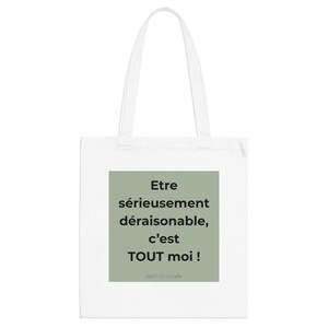 Könnte beinhalten: Weißer Stoffbeutel mit einem grünen Quadrat mit französischem Text. Der Text lautet: „Etre sérieusement déraisonnable, c'est TOUT moi !“ Die Tasche hat zwei weiße Henkel und ist wahrscheinlich aus Segeltuch oder einem ähnlichen Material.