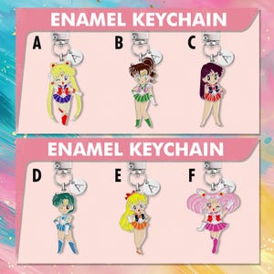 Puede incluir: Llaveros de esmalte con seis personajes de anime diferentes. Cada llavero tiene un cierre plateado y un pequeño dije con la letra "A". Los llaveros son de varios colores, incluyendo rojo, verde, azul y rosa.