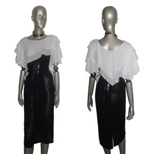 May include: A black and white dress with a white ruffled top and a black skirt. The dress has a belt at the waist.